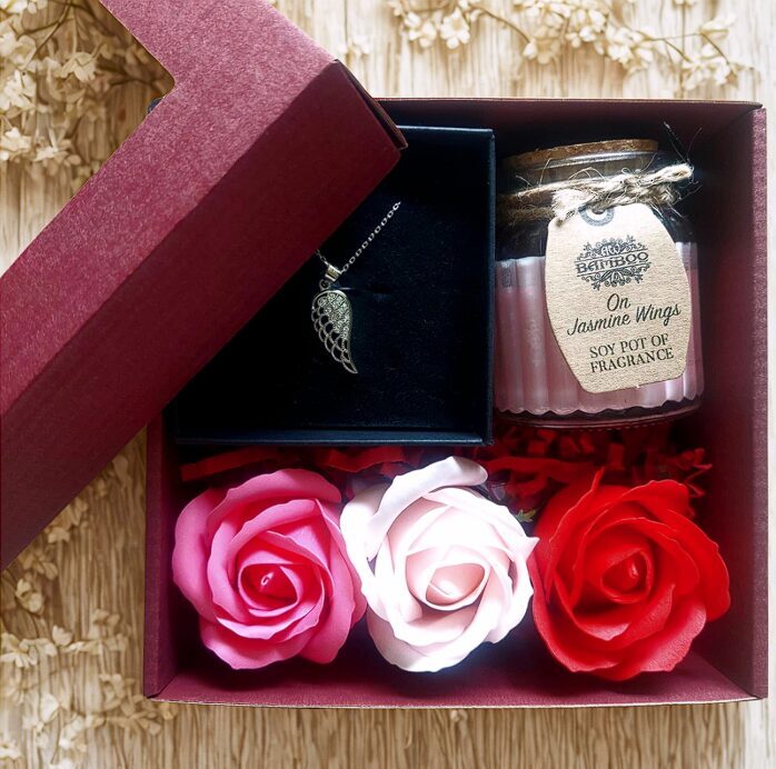 A heartfelt gift for her – a silver pendant, an aromatic candle, and soap roses