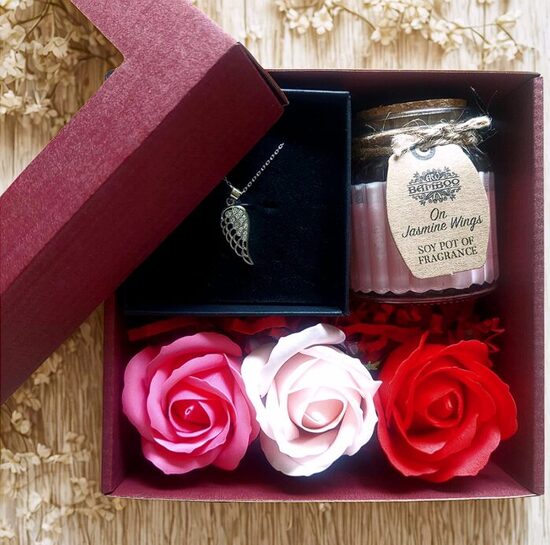 A heartfelt gift for her – a silver pendant, an aromatic candle, and soap roses